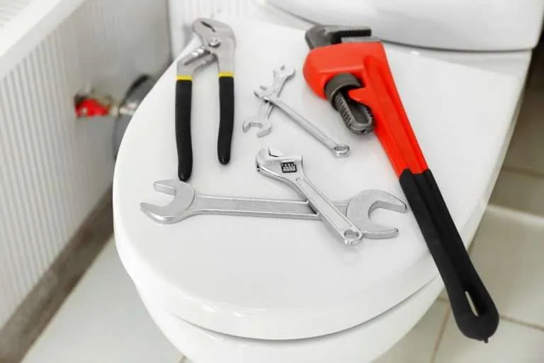 tools sitting on top of toilet